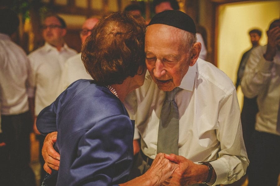 The bride's grandparents hold each others hands and dance together