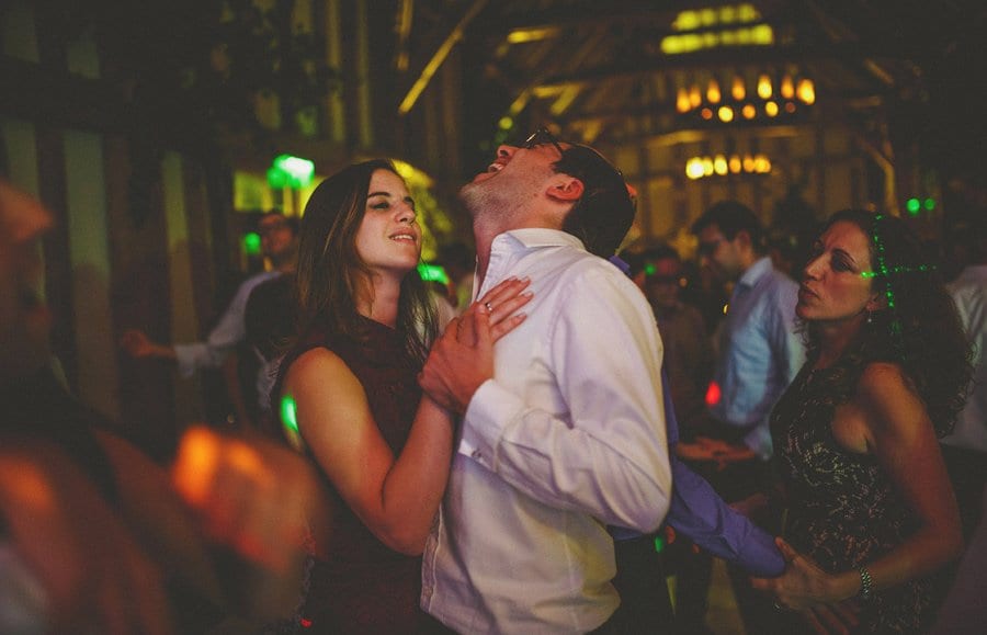 A husband and wife dance together on the dancefloor in the barn