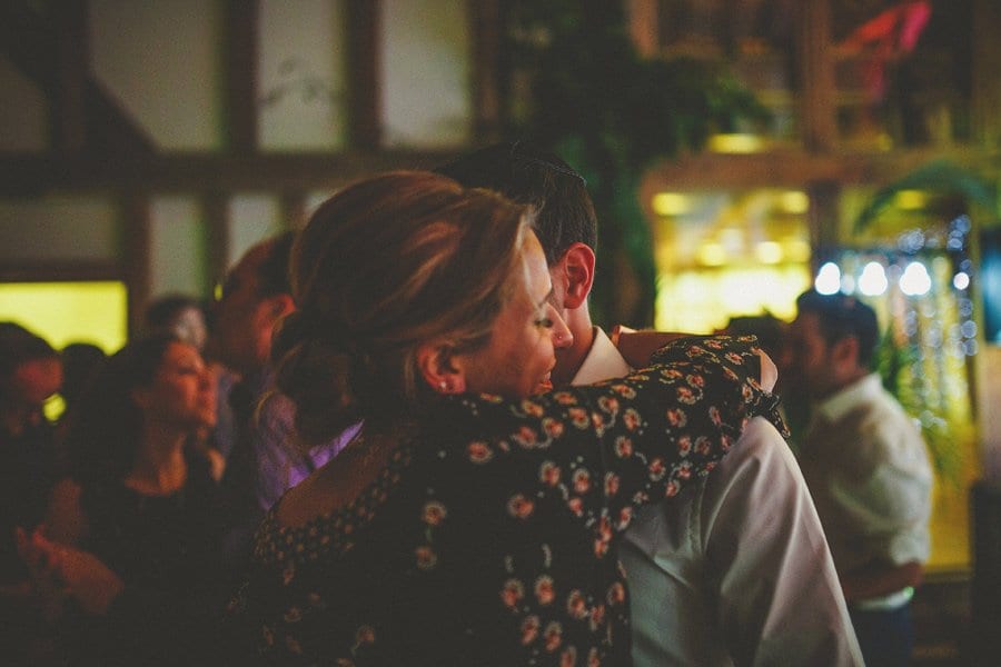 The bride's sister embraces her husband in the barn at Micklefield Hall