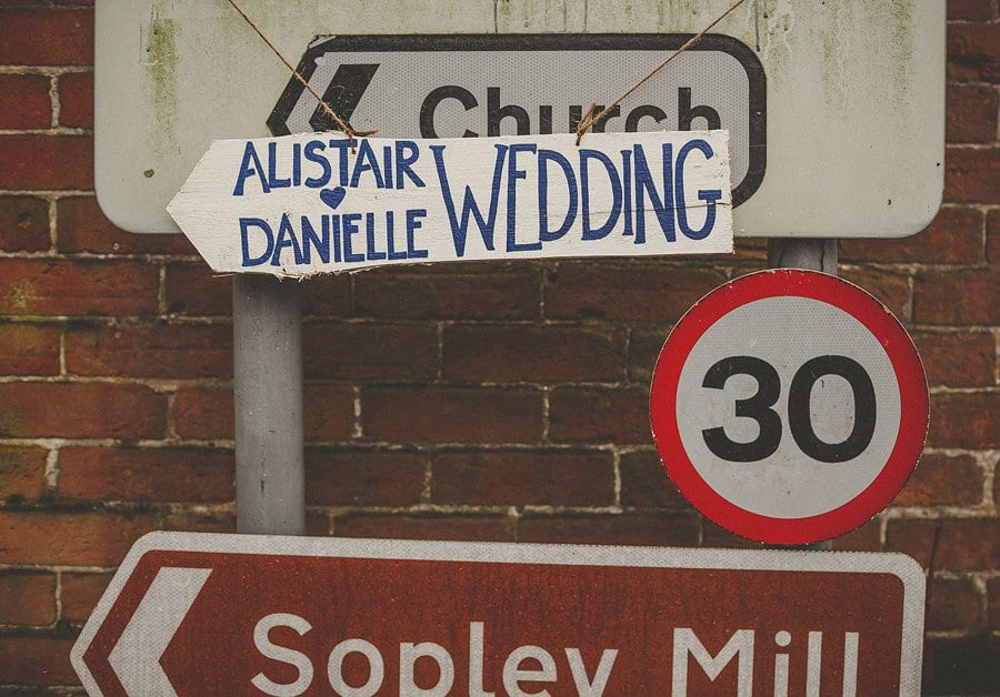 A sign hanging from a road sign showing the wedding of Danielle and Alistair