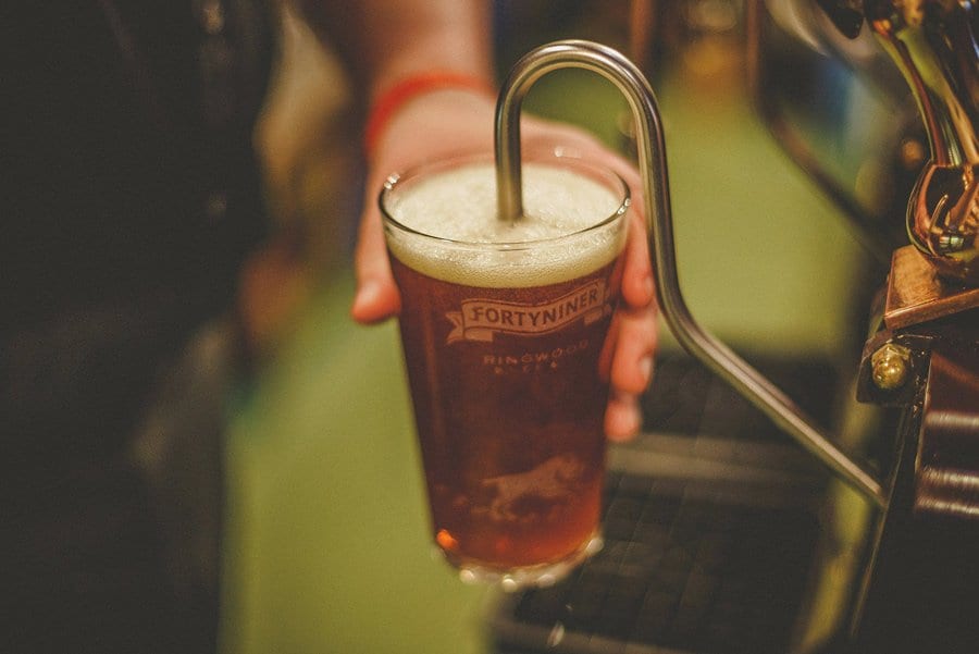 A barman pulls a pint of beer in the pub