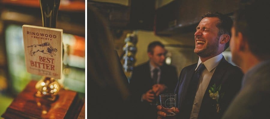 The groom stands at the bar and laughs with an usher