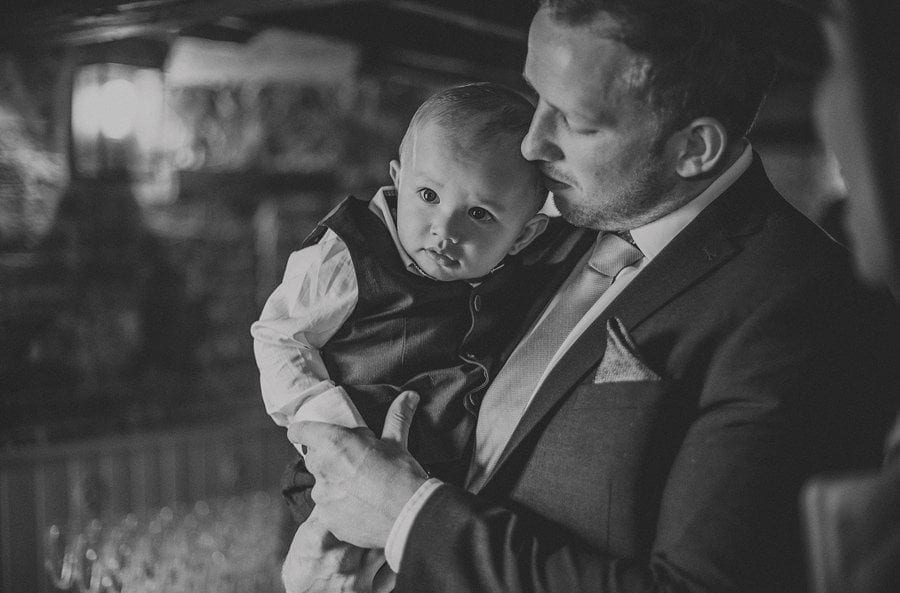 A wedding guest holds his son in his arms