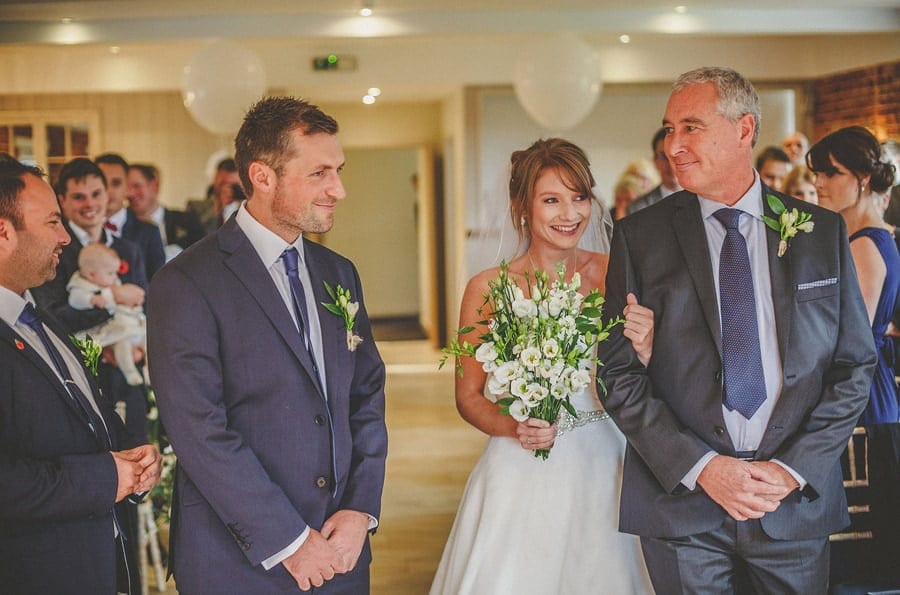 The bride and her father greet the groom for the wedding ceremony