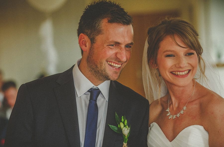 The bride and groom laugh with each other during the wedding ceremony