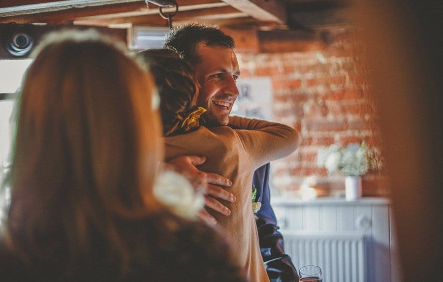 The groom is congratulated by a wedding guest