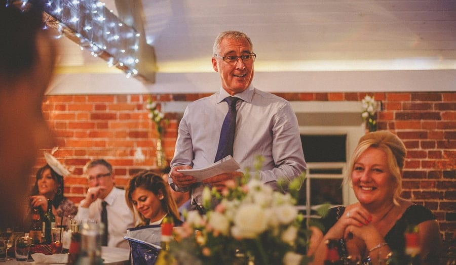 The brides father stands up and delivers his speech to the wedding guests