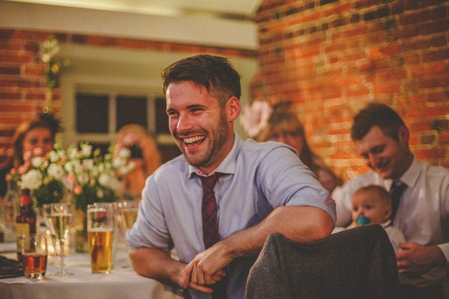 A wedding guest laughs during the best man's wedding speech