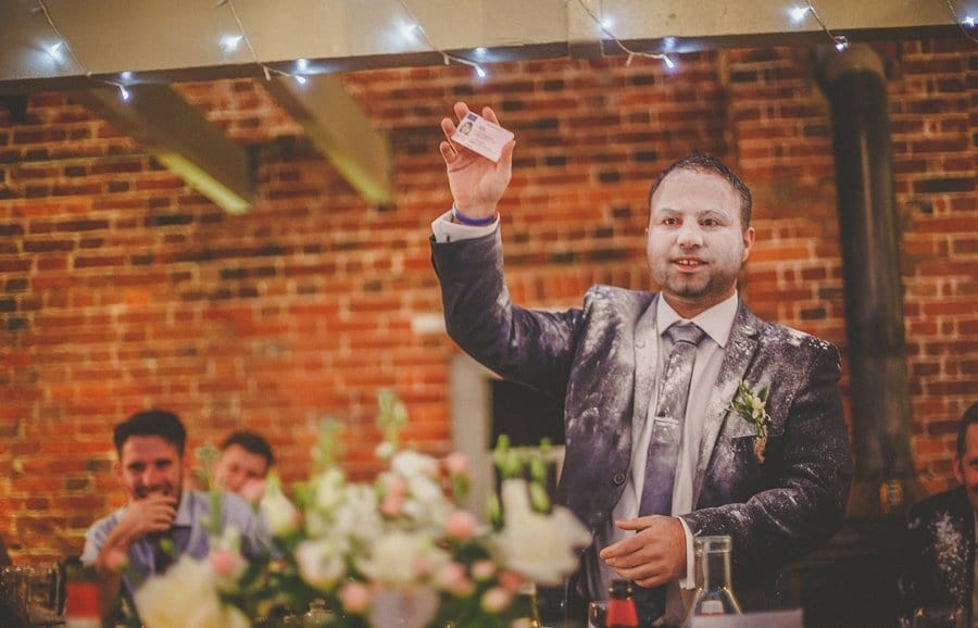 The best man holds up a driving licence during his wedding speech