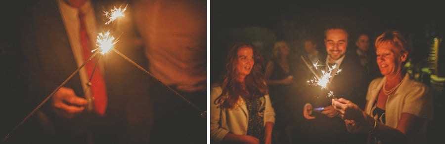 Wedding guests light sparklers outside Sopley Mill in the evening