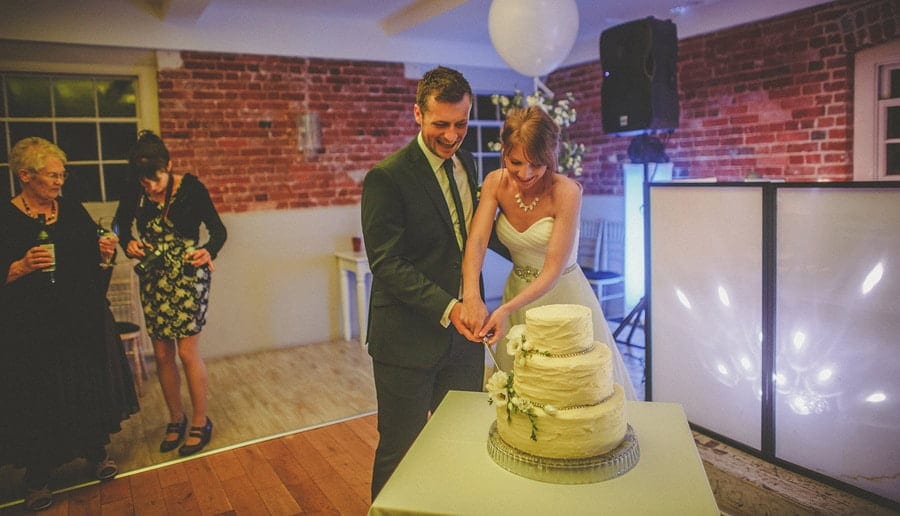 The bride and groom cut the cake on the dancefloor