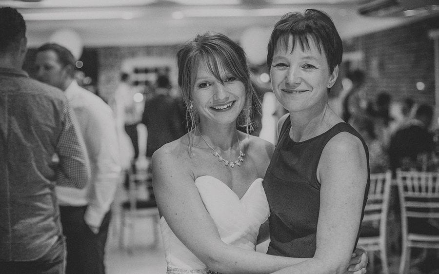 The bride and groom pose for a photograph on the dancefloor