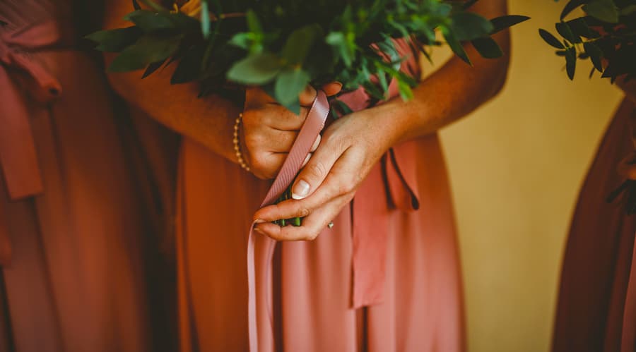 A bridesmaid holds her bouquet of flowers with both hands
