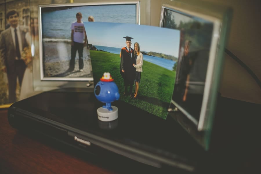 A photograph of the brides brother rests on a DVD player and other photographs