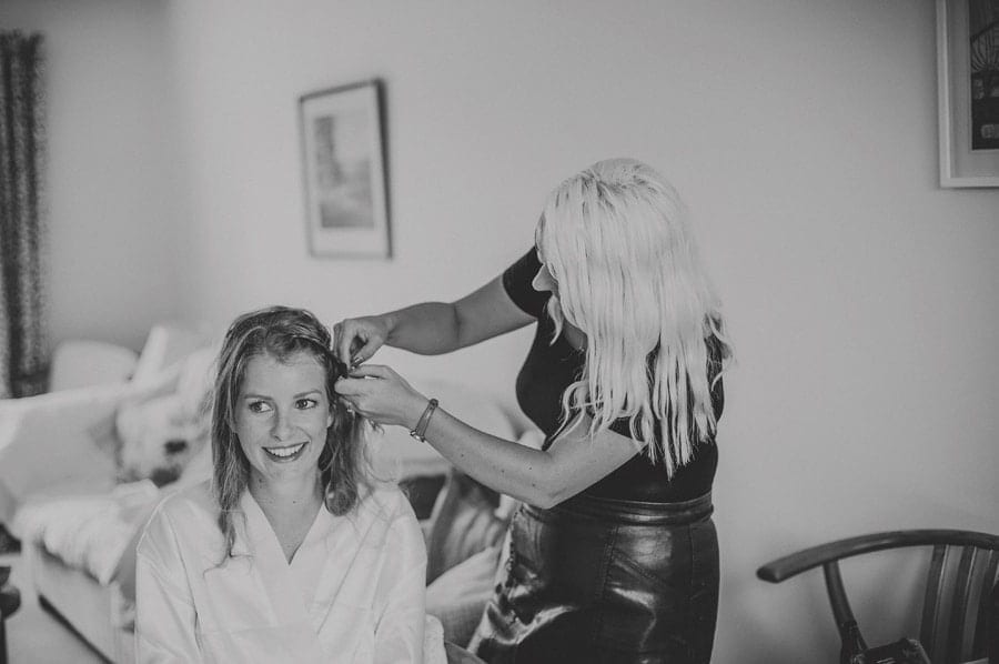 The hair stylist applies a pin to the brides hair