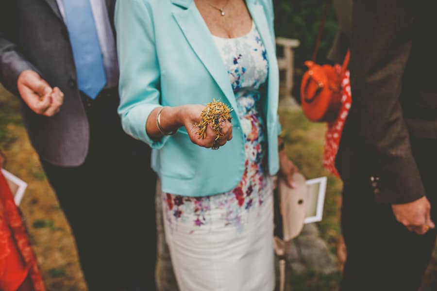 A wedding guest holds confetti in her hand
