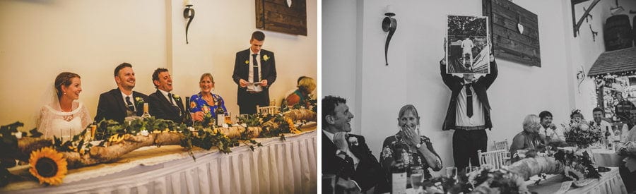 The groom's brother holds up a large photograph of the groom during his wedding speech at Yarlington barn in Somerset