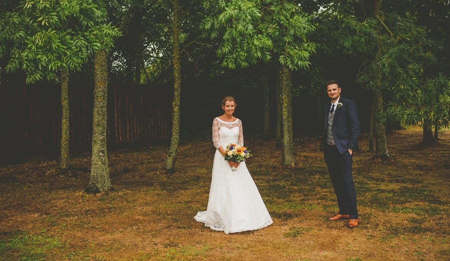The bride and groom pose for a photograph in the gardens at Yarlington barn in Somerset