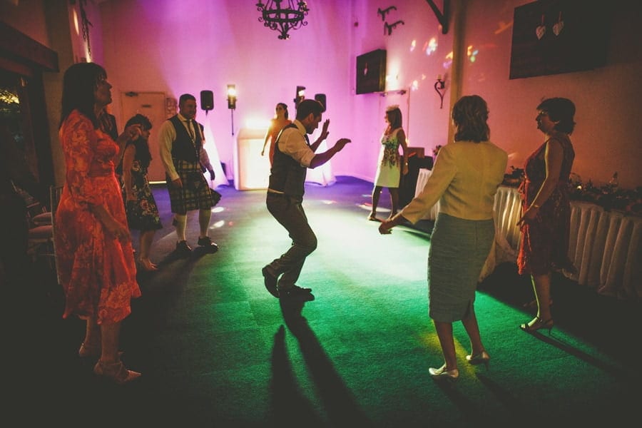 A wedding guest dances on his own as others watch him at Yarlington barn