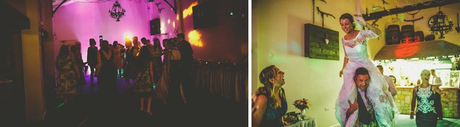 A wedding guests lifts the bride onto his shoulders on the dancefloor at Yarlington barn in Somerset