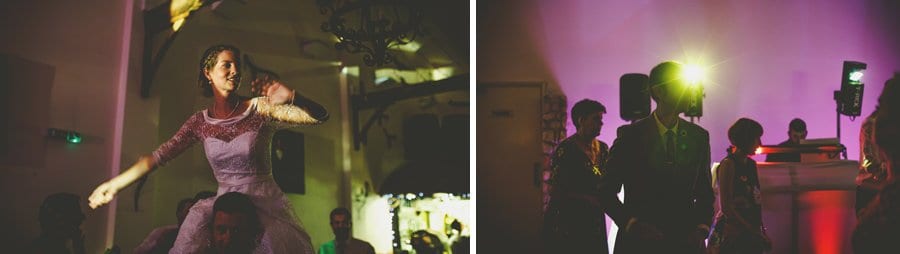 The groom lifts the bride onto his shoulders on the dancefloor