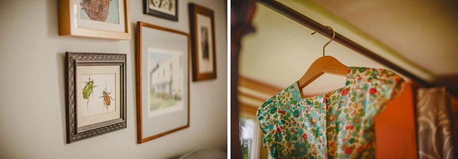 A flower girls dress hangs from a rail next to a window