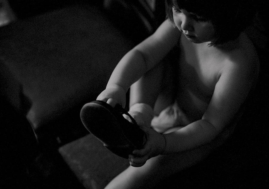 A flower girl puts on her new shoes