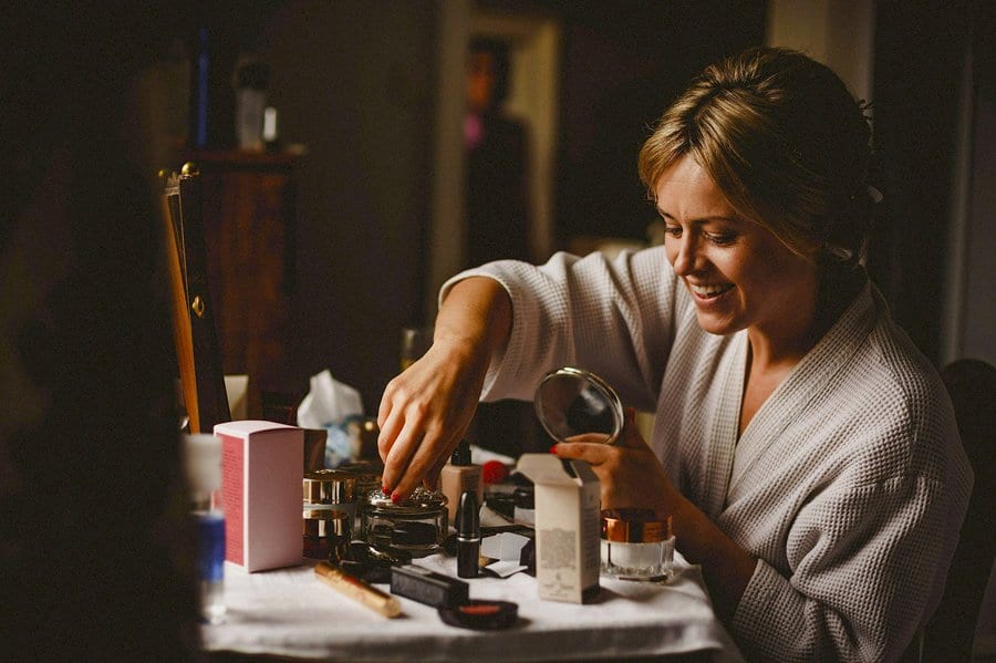 The bride smiles as she listens to her sister talking in the next room