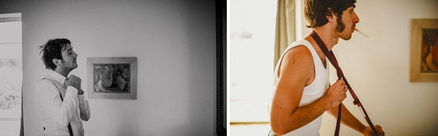 The groom and his usher looks into mirrors hanging from the wall as they get ready