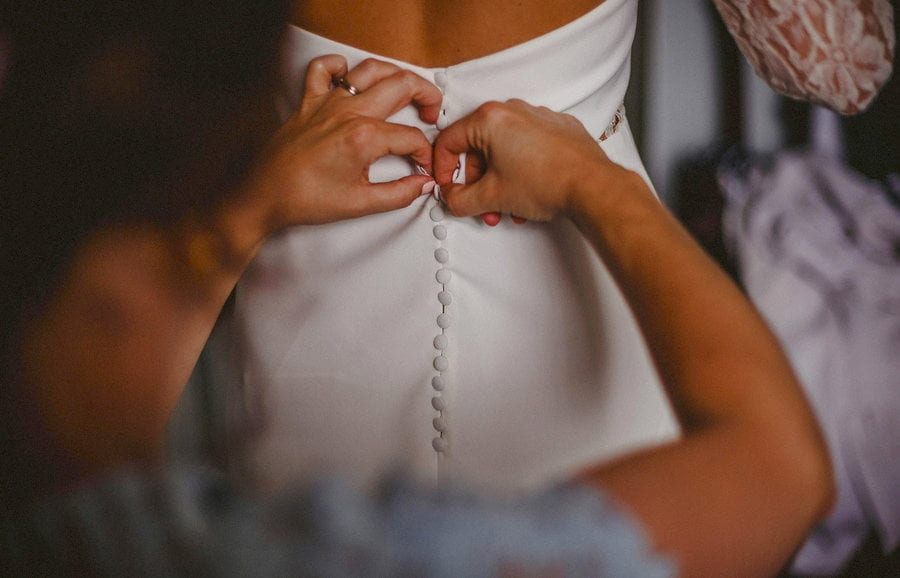 Helping the bride get her dress on