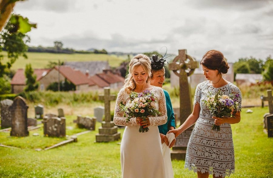 The bride and her family stand at the door of the church and wait for the ceremony to begin