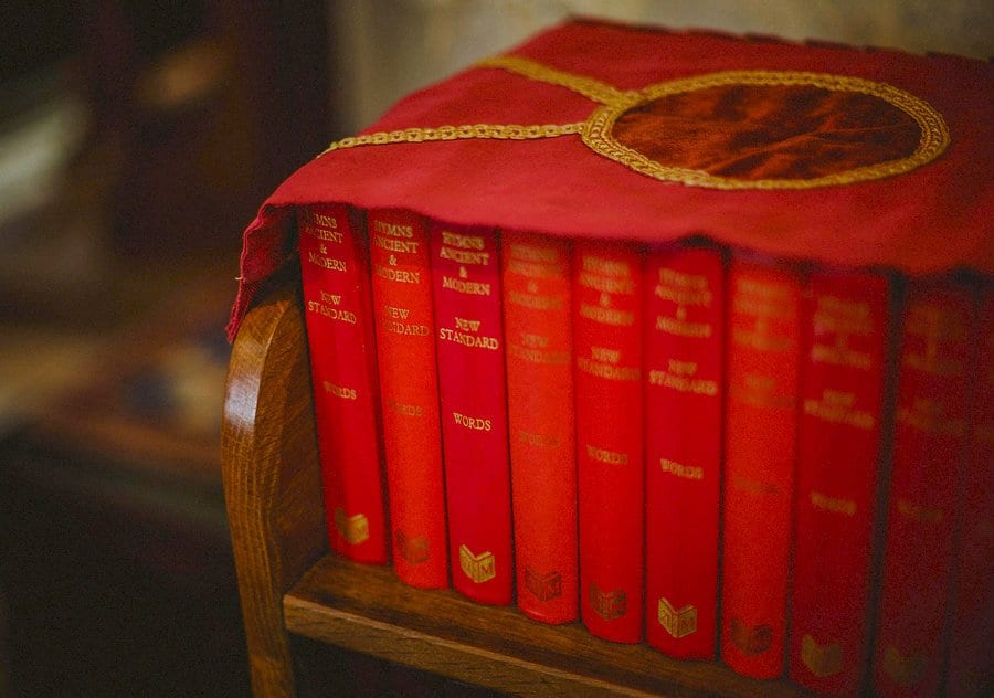 Church hymn books rest on a shelf