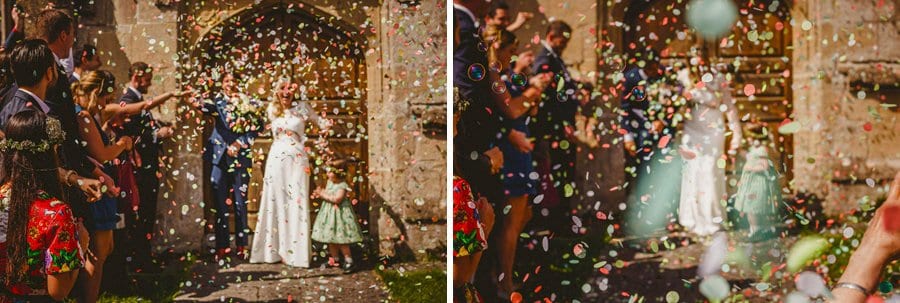 Wedding petals shower the bride and groom outside Batcombe church