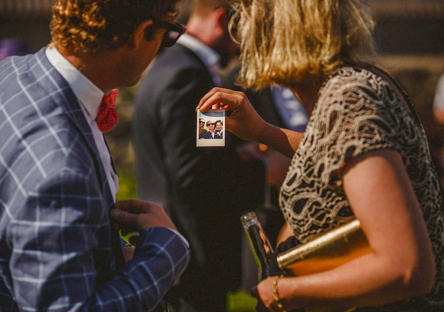 Couples take photographs of each other with polaroid cameras