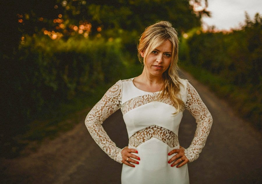 The bride poses for a photograph along a country lane outside Penny Square Barn