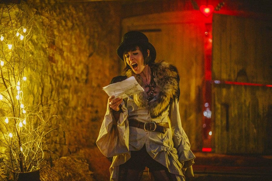 A bridesmaid sings a song to the crowd that have gathered outside the barn