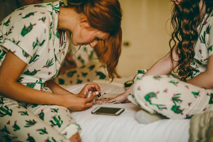 A bridesmaid puts on nail varnish in the main bedroom at Wilderness Reserve