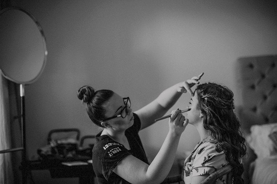 A make up artist applying make up to a bridesmaid