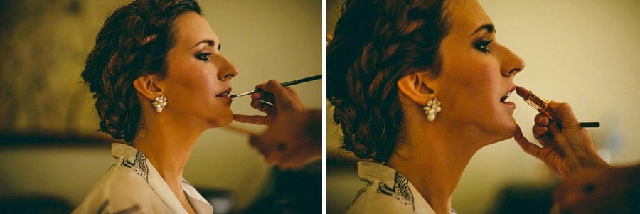 The make up artist applies lip stick onto the brides lips