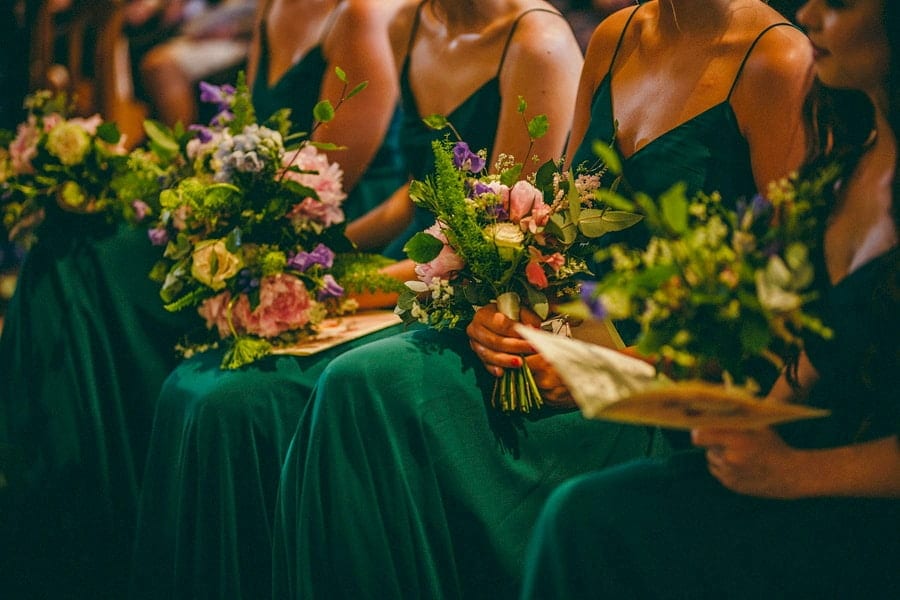 The bridesmaids sit together during the wedding ceremony at St. Benets Minster