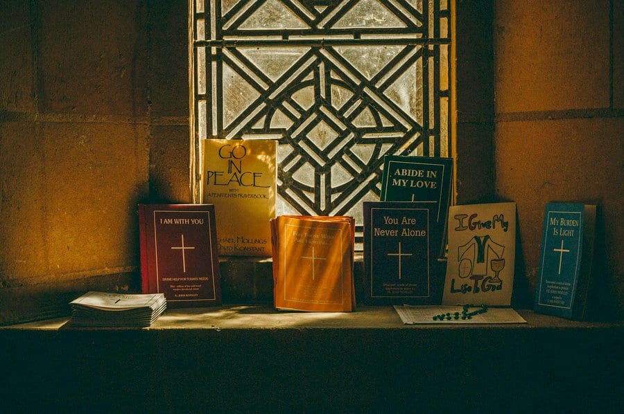 Wedding hymn books lay on a stone window ledge