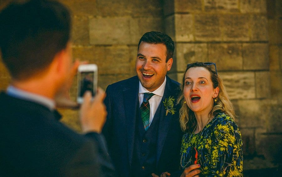 The groom poses for a photograph outside the church