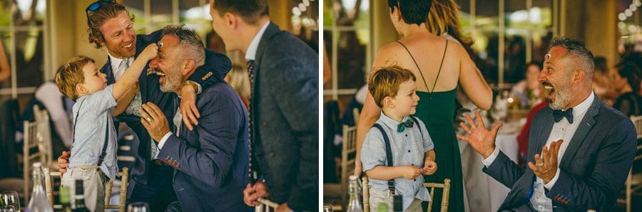 A boy puts a sticker on his fathers head