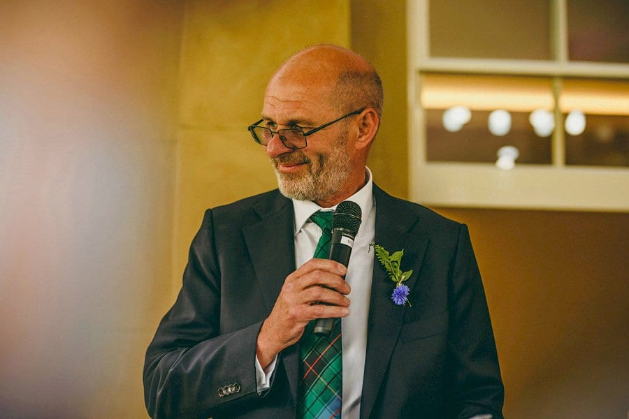The brides father stops and looks at his daughter during his speech