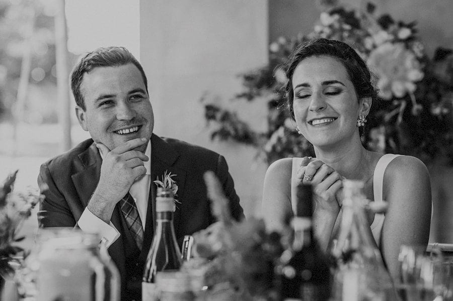 The bride and groom laugh during the speeches