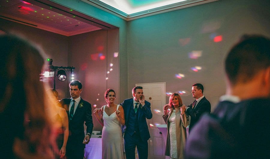 The groom shouts to a friend on the dancefloor