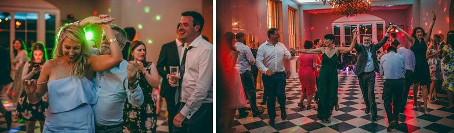 Wedding guests on the dancefloor all hold hands together