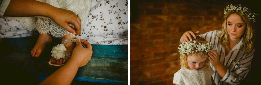 The bride fastens the flower girls strap on her new shoes