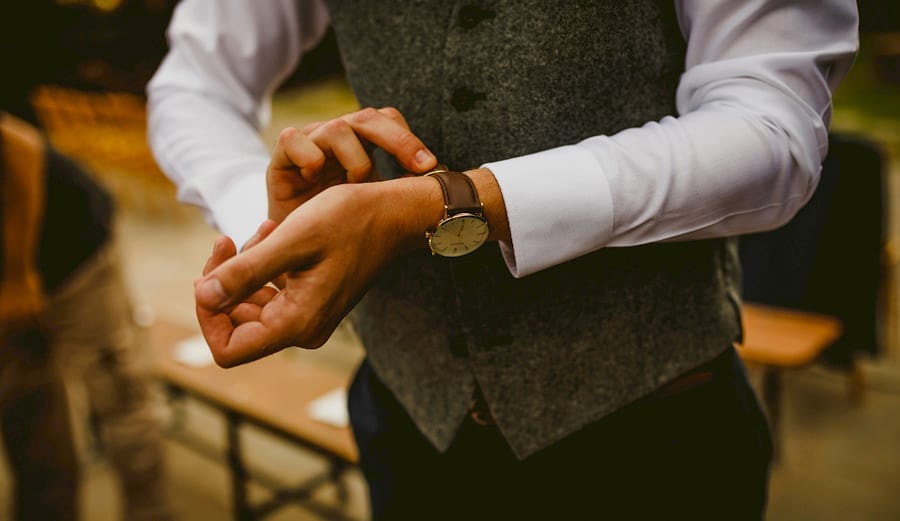 An usher fastens a watch to his wrist