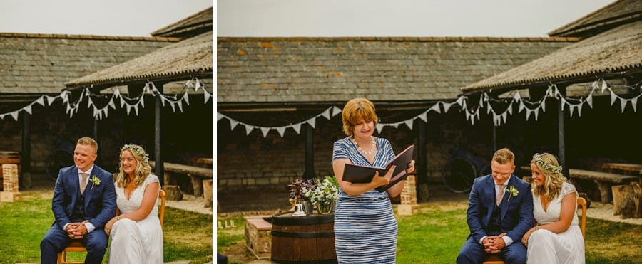 The bride and groom sit in chairs next to each other and listen to a lady speaking during the wedding ceremony